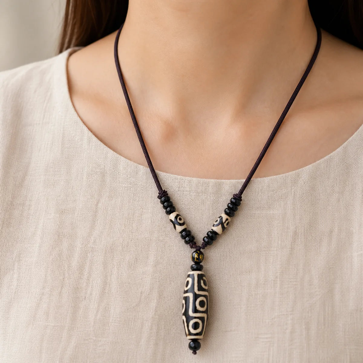 Nine-Eye Dzi bead necklace worn by a woman